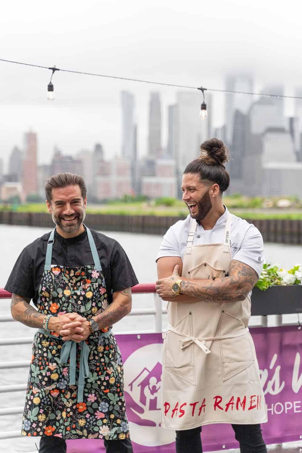 Chef Robbie Felice with a colleague in front of a pastaRAMEN banner, Manhattan skyline behind